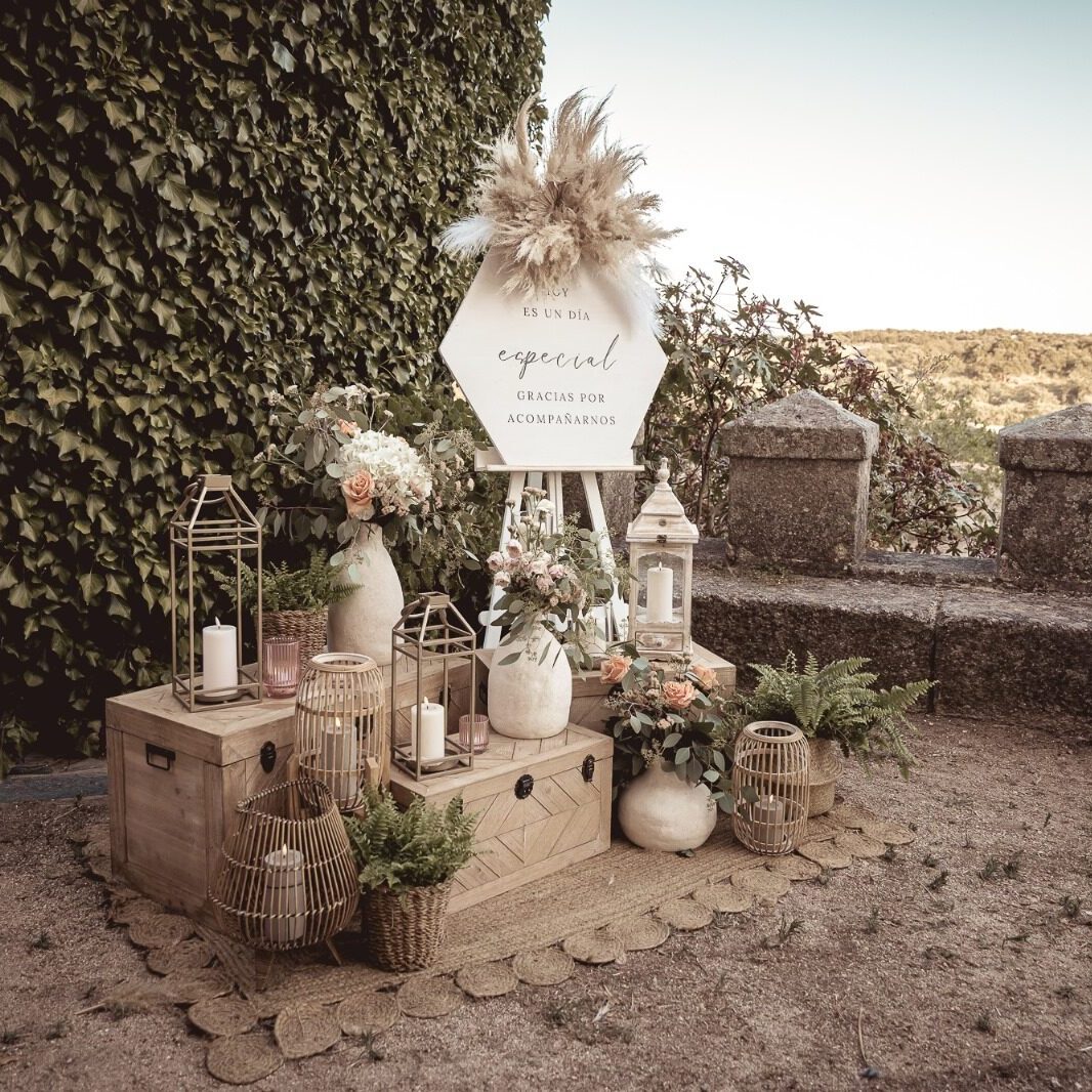 Cartel de agradecimiento personalizado, acompañado de plantas y farolillos decorativos sobre alfombra de yute.